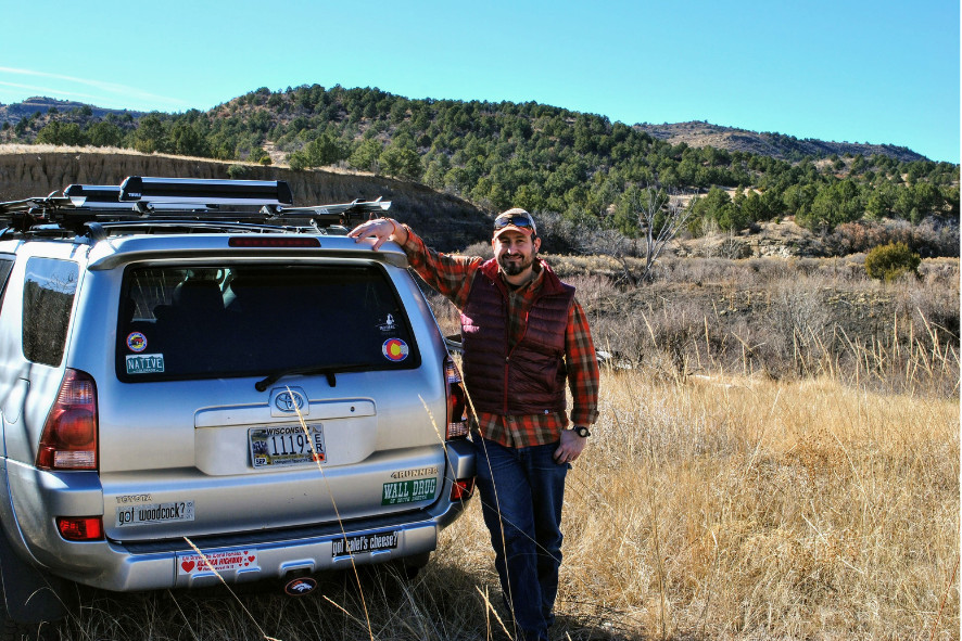 Davin standing next to a car while out doing field work.