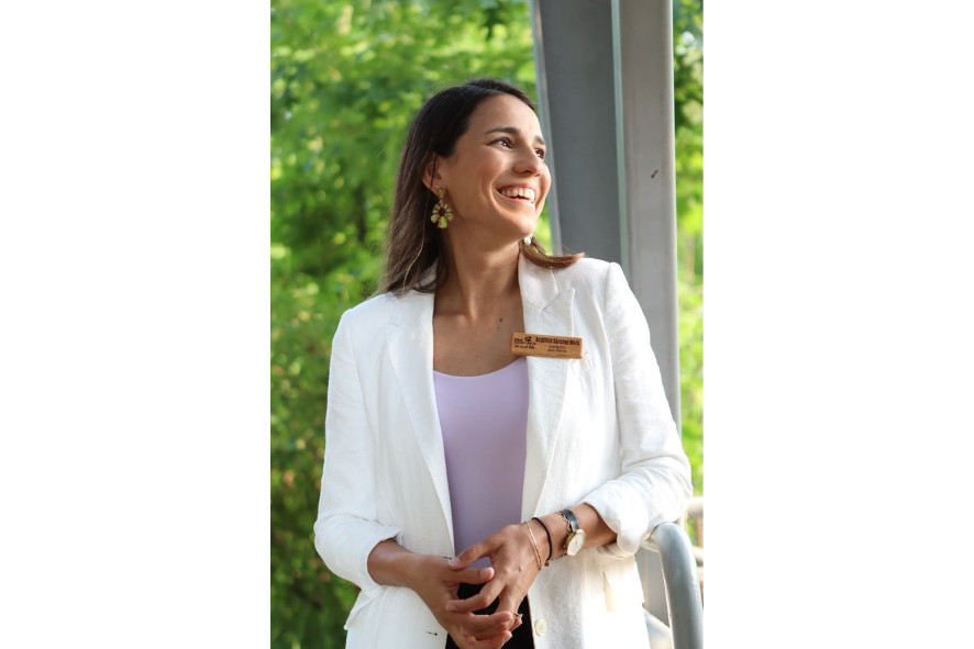 Headshot of Angelica wearing a white jacket and looking off camera, smiling