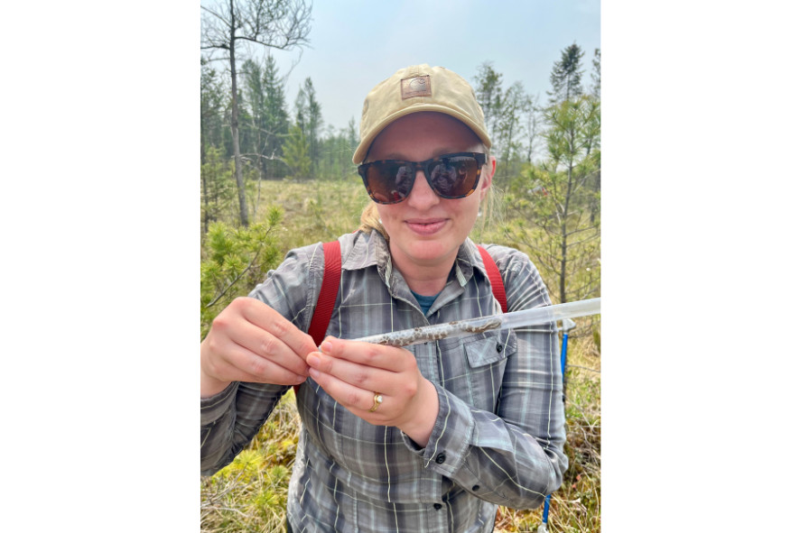 Cait holding a tube with a massasauga rattlesnake inside of it, image for Cait's 10-year anniversary blog