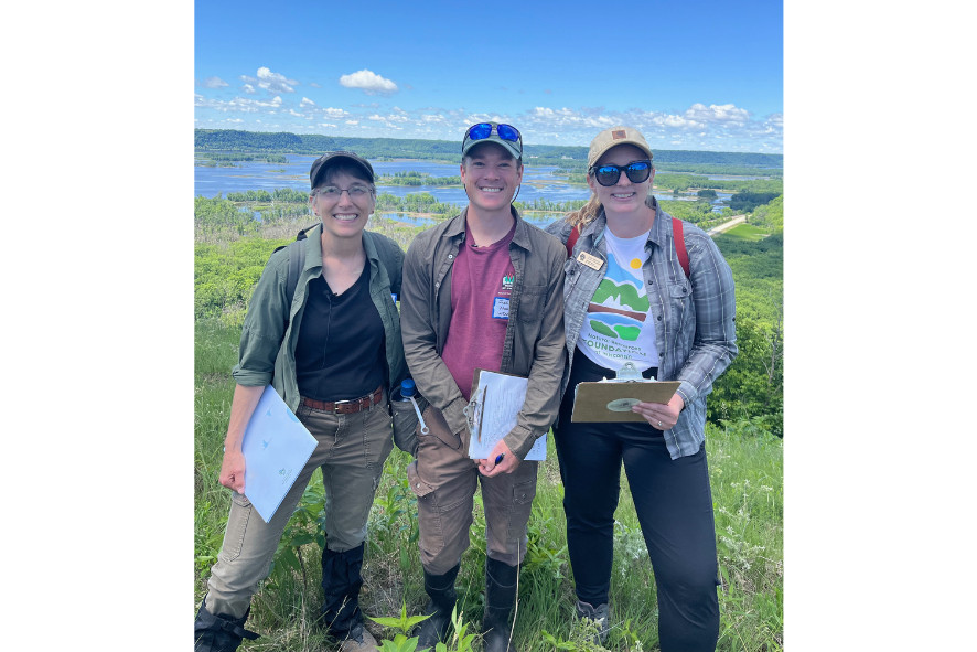 three people standing on a hillside at Rush Creek State Natural Area, image for Cait's 10-year anniversary blog