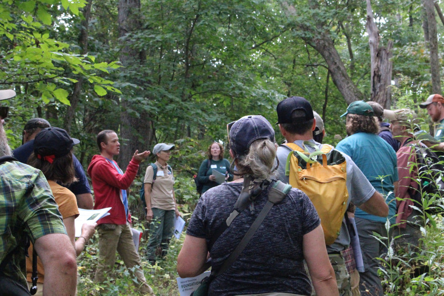 people on a hike listening to someone speak