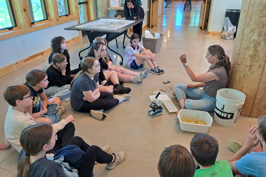 An employee from Camp Y-Koda engaged with students at the Kohler Center, teaching them how to explore and identify the macroinvertebrates they collected from the Marsh