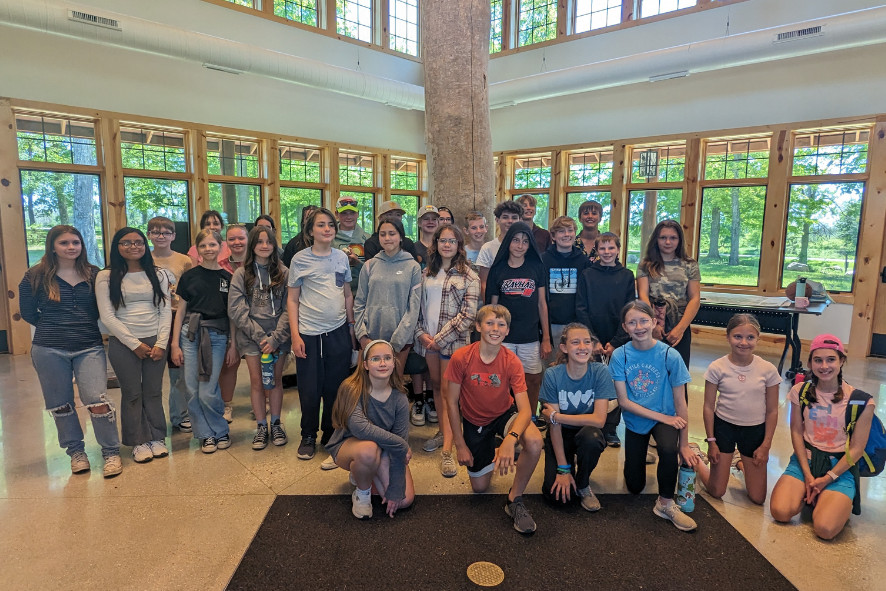 Seventh grade class taking a group photo inside a building