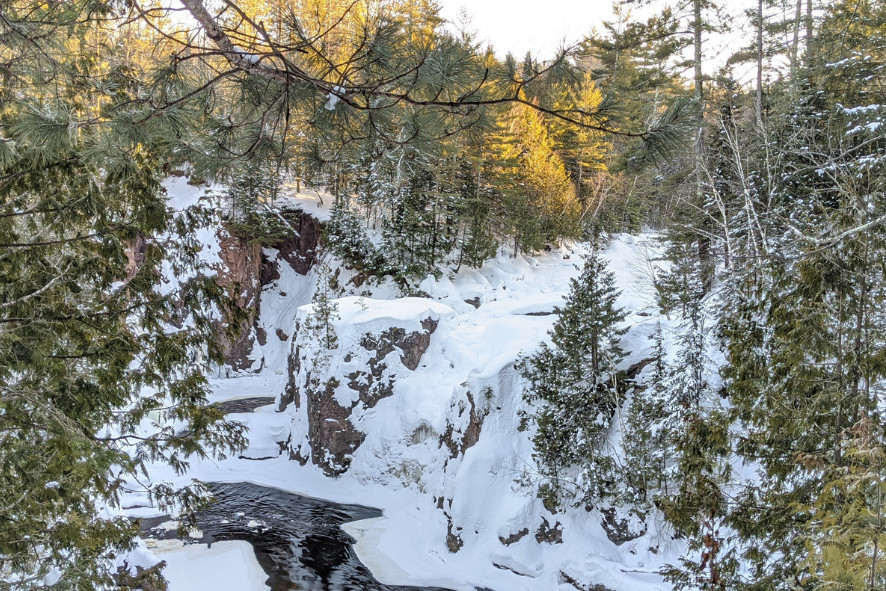 A snow covered cliffside above a river at one of Wisconsin’s state parks