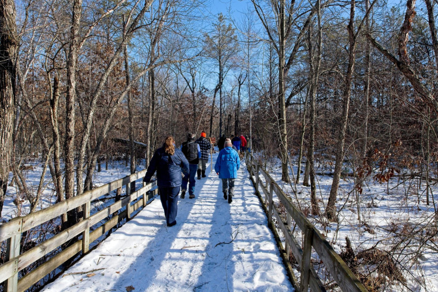 People walking over a snow covered bridge at one of Wisconsin’s state parks