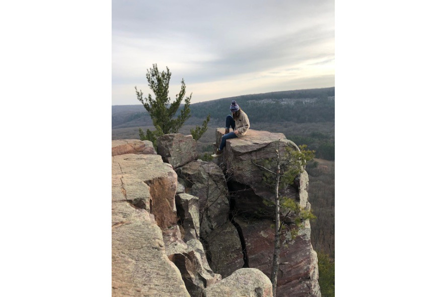 Person sitting on a rock bluff at Devils Lake State Park