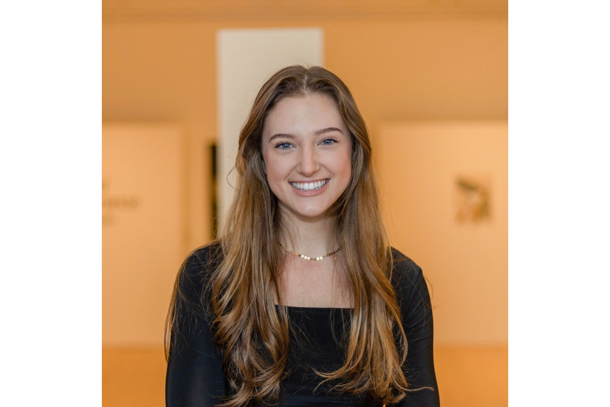 Headshot of a woman with long light brown hair wearing a black long sleeve shirt